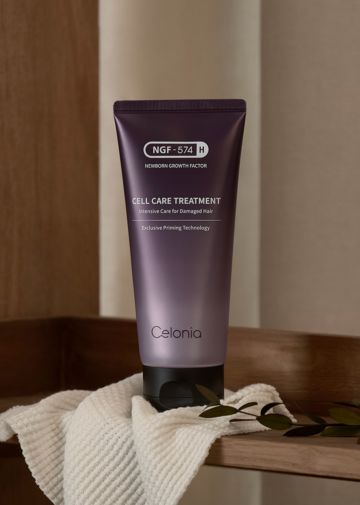 Purple tube of Celania Cell Care Treatment on a wooden surface with a white towel and green leaves.