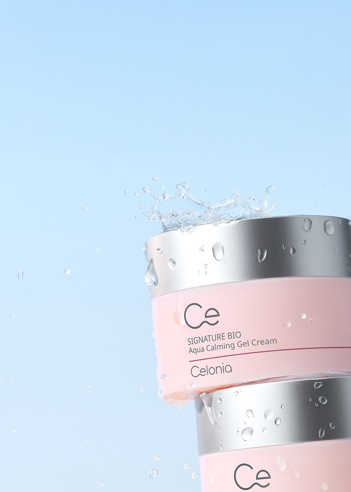 Pink jar of Celonia skincare product with water droplets on a light blue background