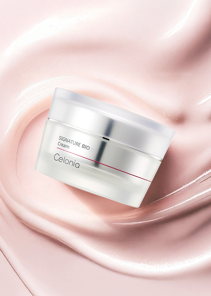 Cosmetic cream jar labeled 'Signature Bio Cream' by Celonia on a pink liquid background